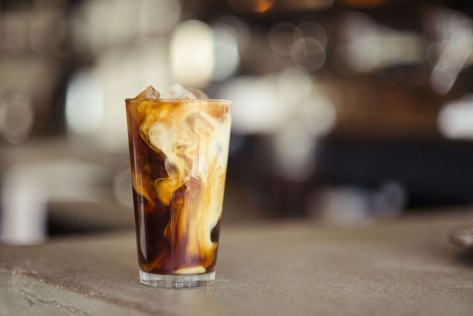 Iced coffee with cream swirling in