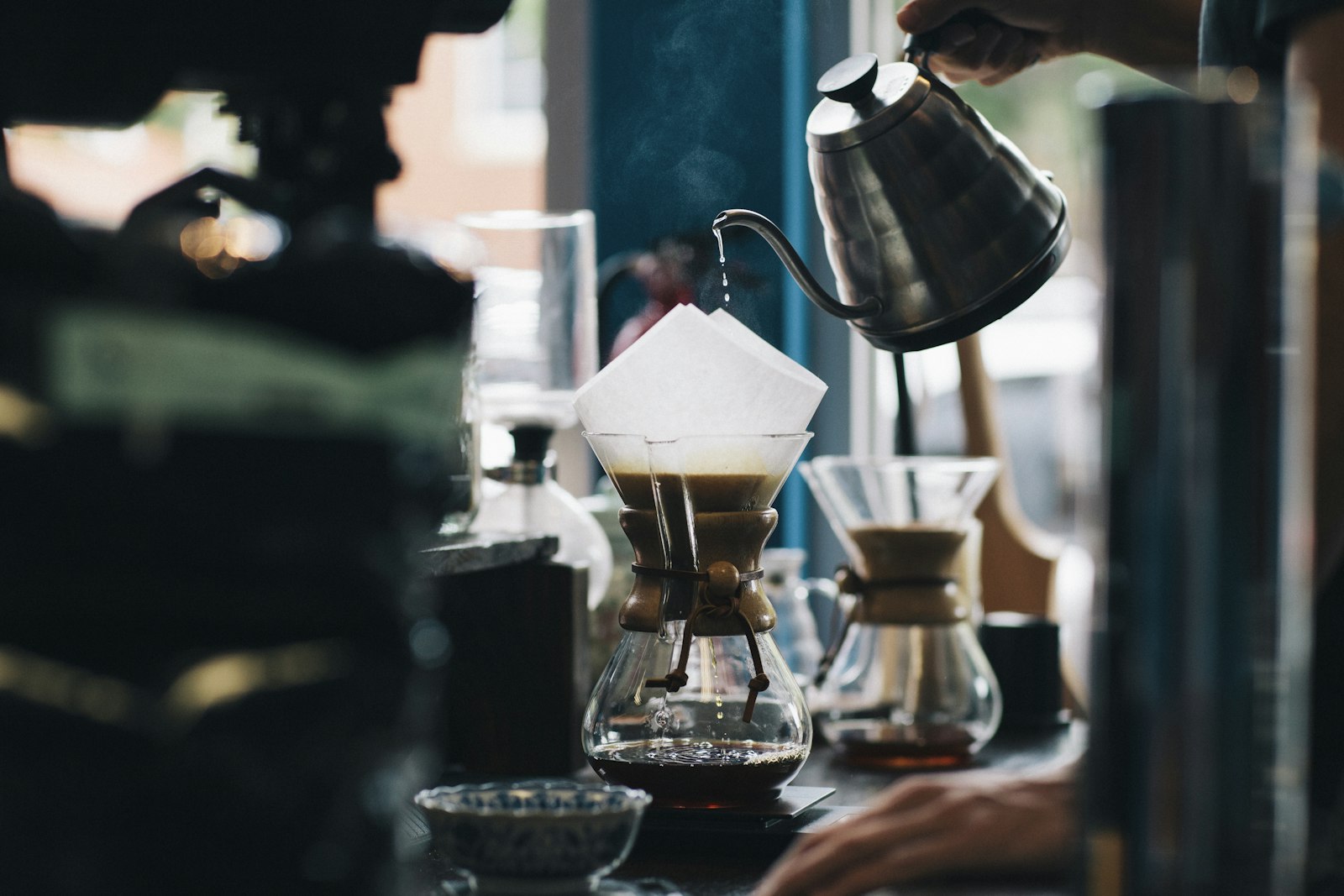 Barista pouring hot water over a pour-over coffee